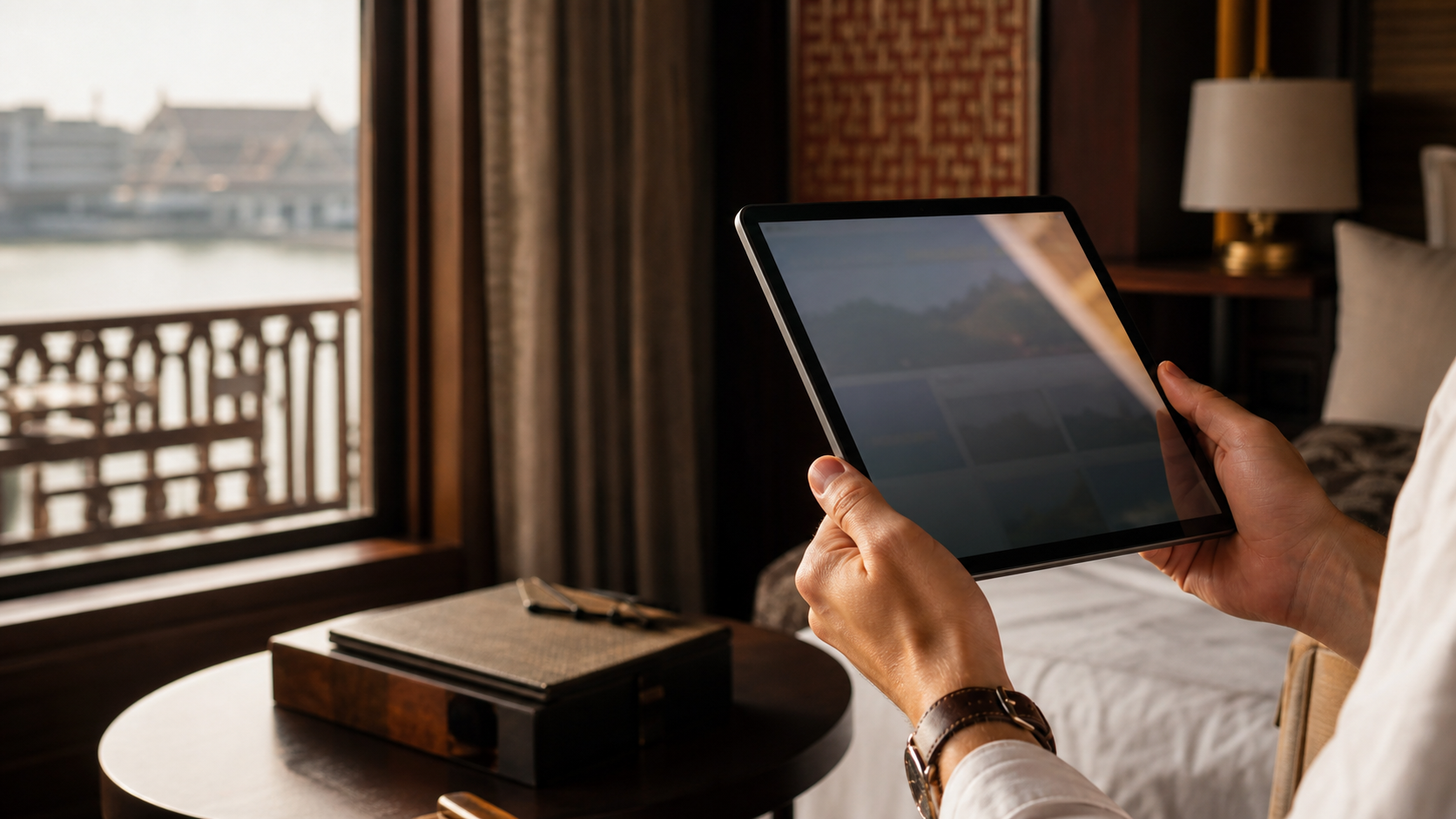 Manos consultando un itinerario en iPad dentro de un hotel tailandés